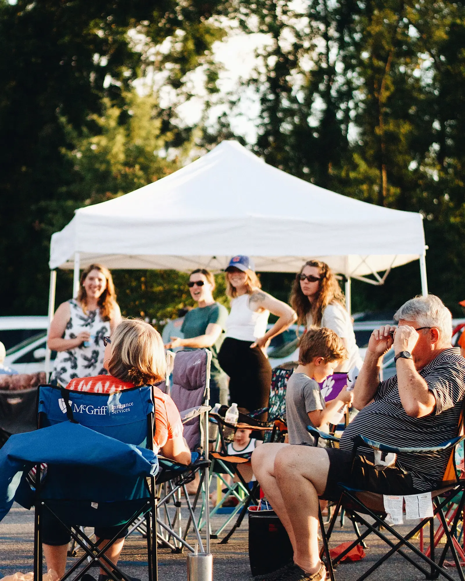 Community gathering under a marquee with open-air seating.