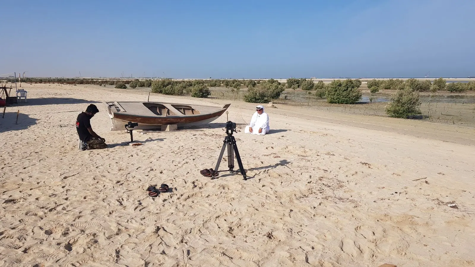 Camera crew filming an outdoor heritage scene on location in the UAE desert.