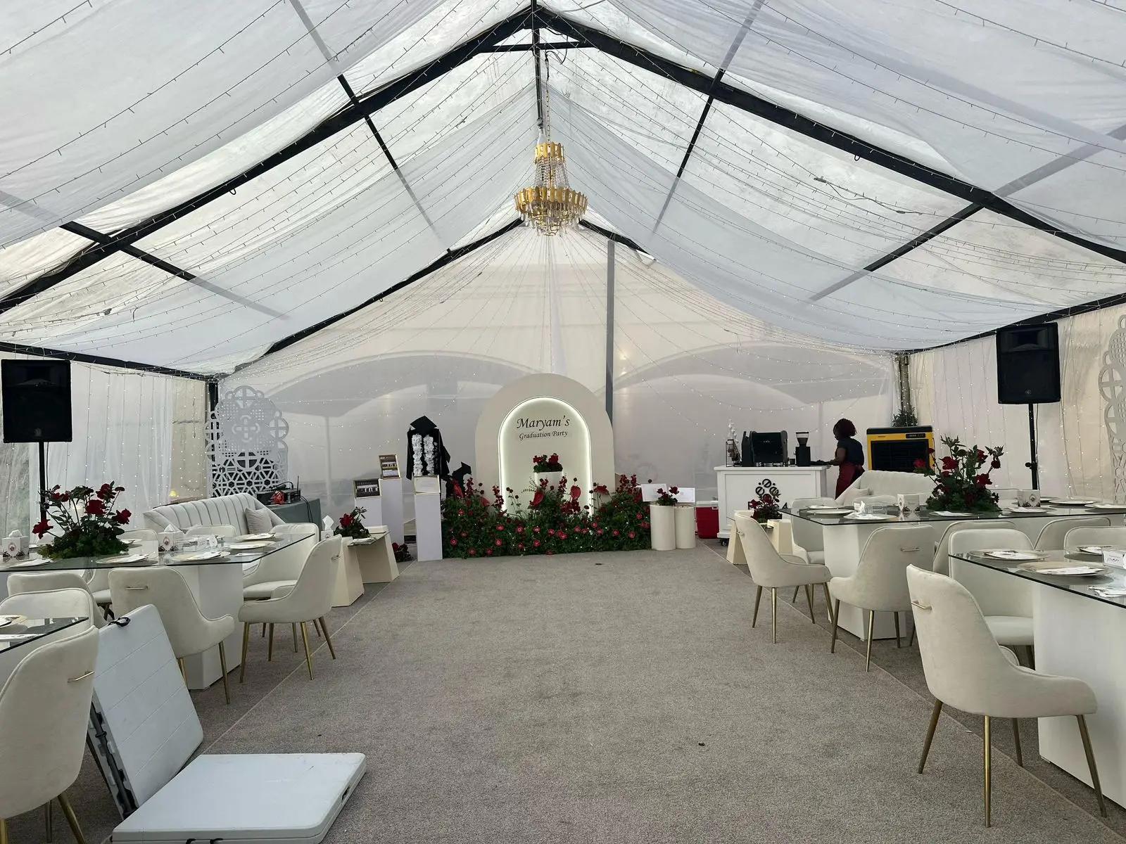 White wedding marquee prepared with lounge seating and a central floral feature.
