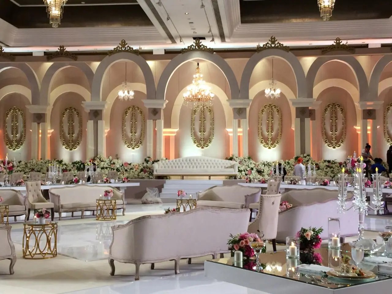 Wedding stage and lounge finished in white and blush tones with floral detailing.